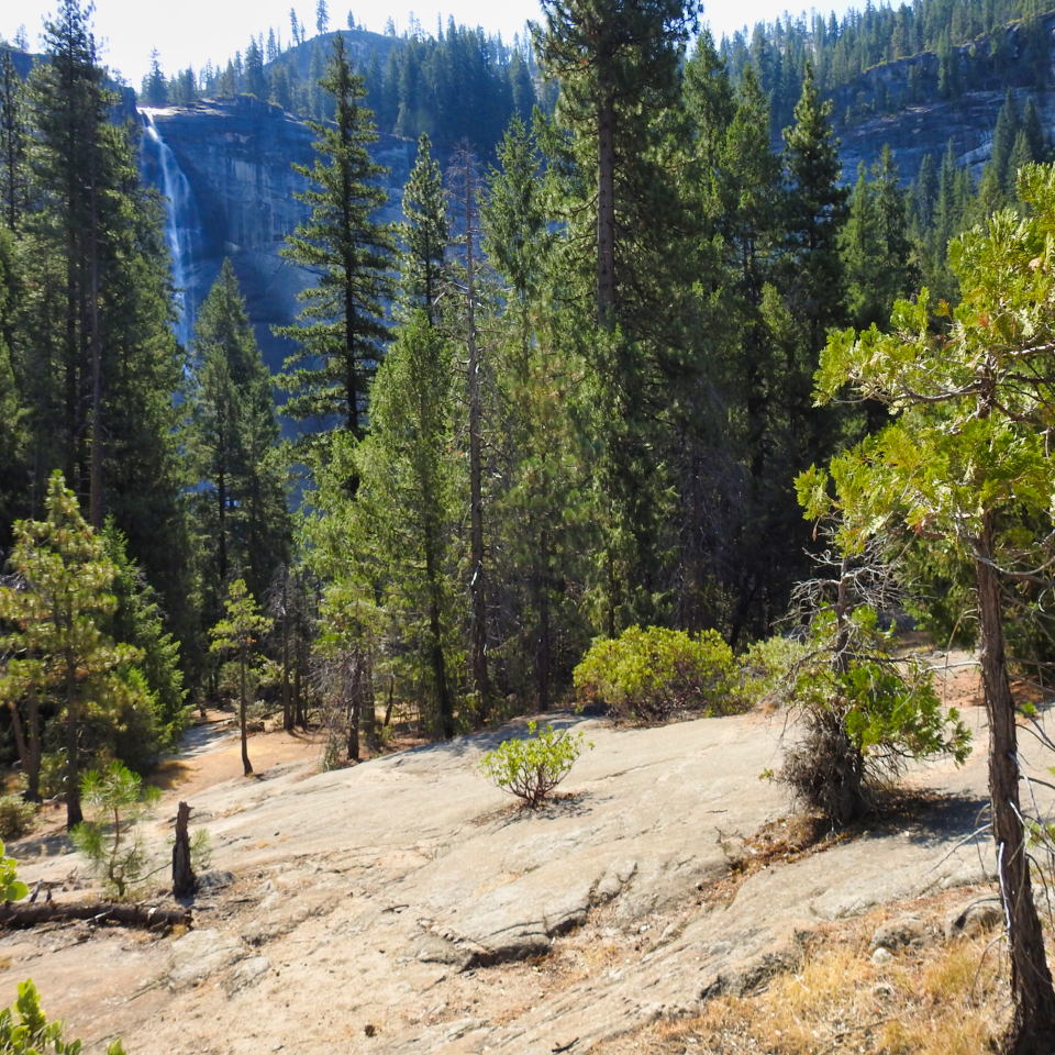 House with people sitting porch and waterfall behind