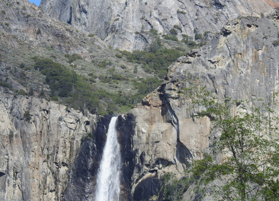 Watercolor painting of cliffs and waterfall.