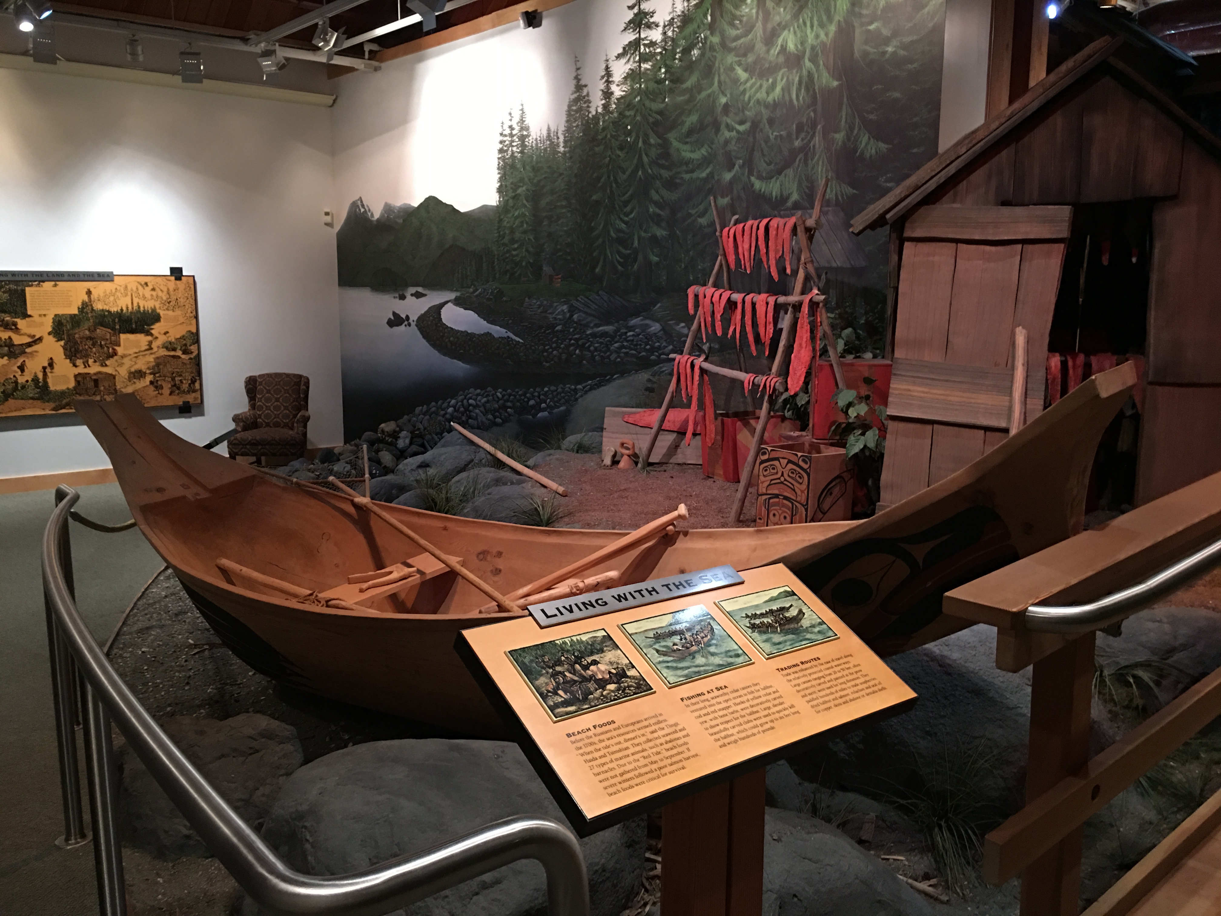 Outdoors; Large green roofed wooden building with evergreen tree next to entrance.