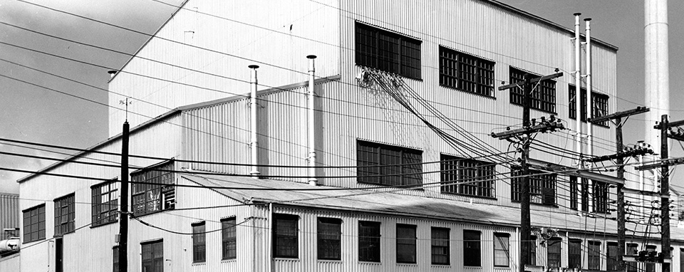 Black and white photo of multistory, white building with lots of windows.