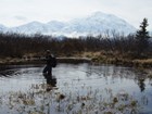 person standing in a knee deep pond