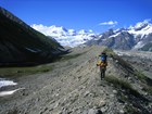 Hikers walk along the ridge top of a lateral moraine (Wrangell-St Elias National Park, AK)