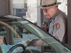 A park ranger speaks with visitors in a car