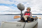 Jennifer Jerrett records sounds in a canoe on a lake.