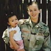 A women in uniform holds a child