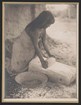 Historic photograph of an O'odham woman grinding grain.