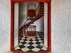 Photograph of doorway into central stairwell of lighthouse tower with red spiral staircase