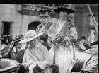 Jeannette Rankin standing up in an open-topped car with four other women around her