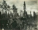 Historic photo of prospectors and their log cabin.