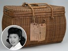Wicker basket with handles and tags, portrait of Japanese American girl.