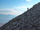 People working on rocky steep mountainside
