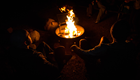 a campfire glows at night