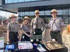 four people in park ranger uniforms standing behind an info booth