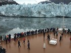 Visitors on a cruise ship view a glacier up close.