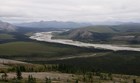 A river valley surrounded by mountains and forest.