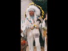 Tribal elder man, headdress of black & white feathers, white buckskin pants, shirt with beadwork.
