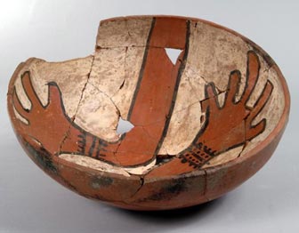 ancestral pueblo bowl with a chipped rim, depicting two hands inside the bowl