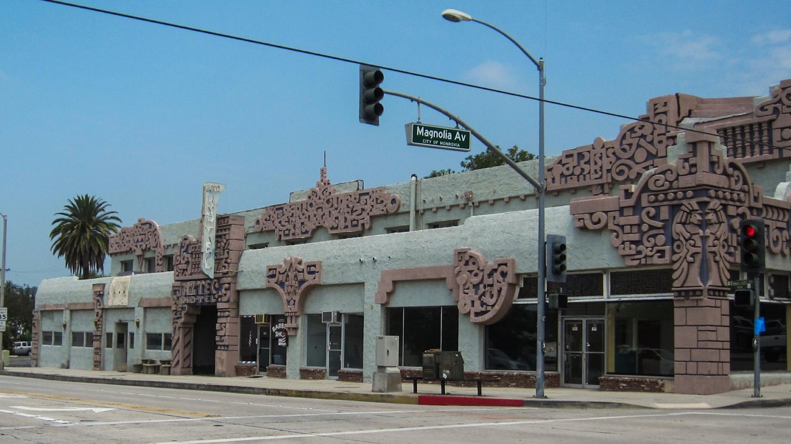 A muted teal two story building with ornate tan detailing. 