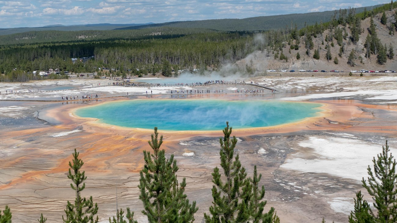 A large, colorful hot spring as viewed from above.