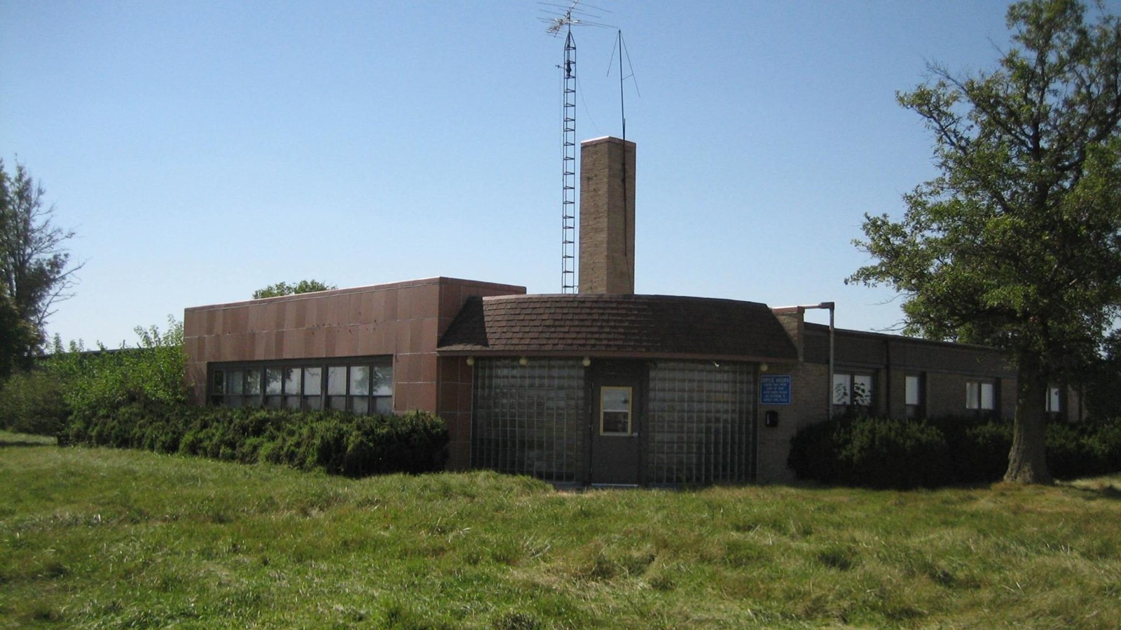A tan building with curved edges and large windows. 