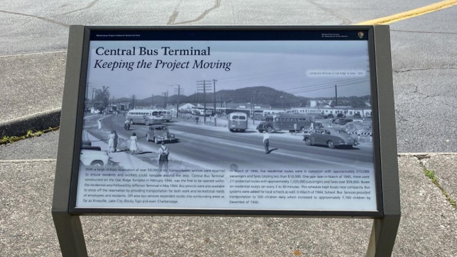 A wayside exhibit in front of a curb in a parking lot.