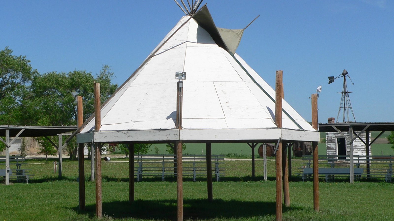A circle of poles topped with a white peaked roof