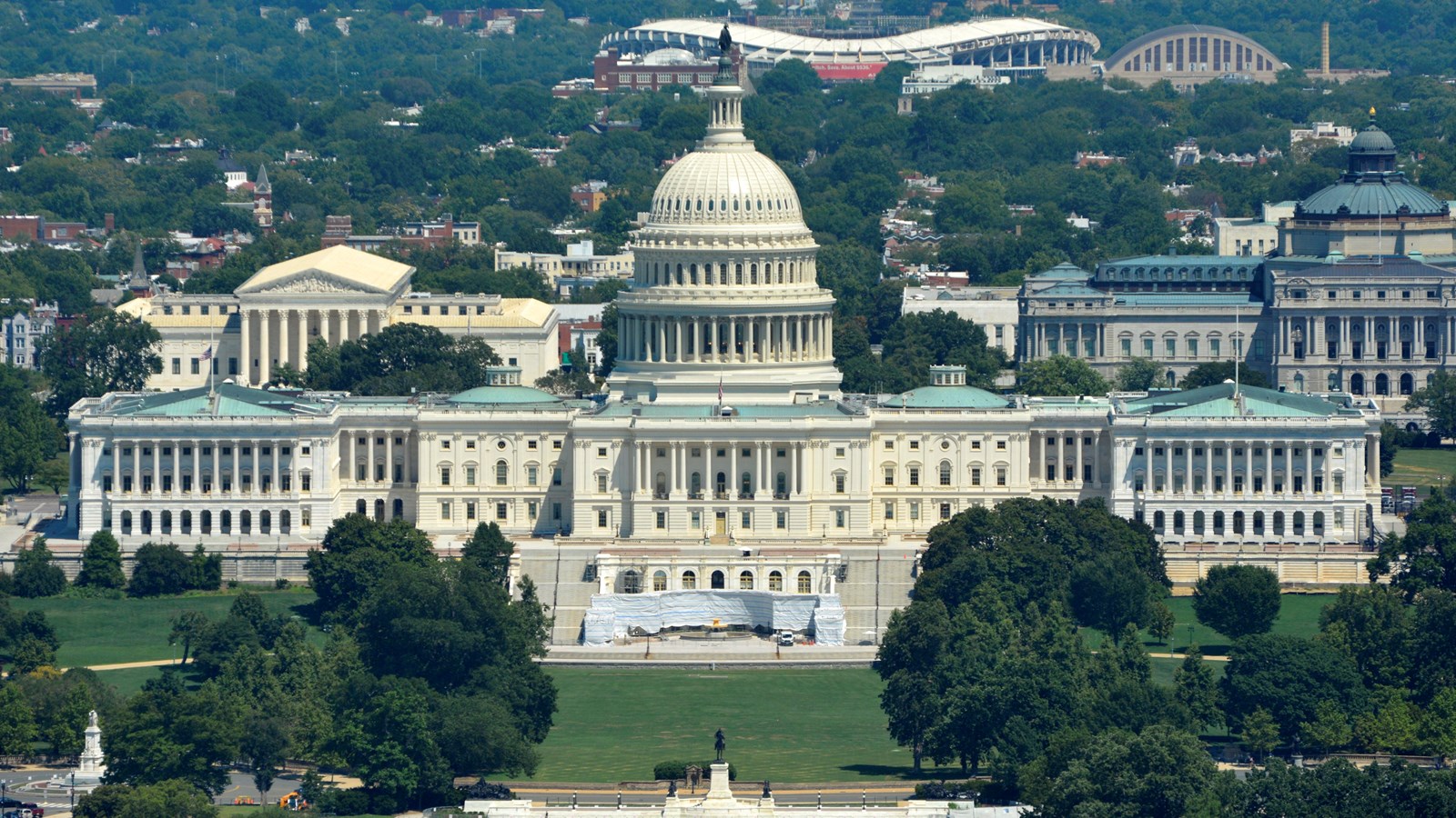 Large white building with a wing on either end and a tall dome in the center
