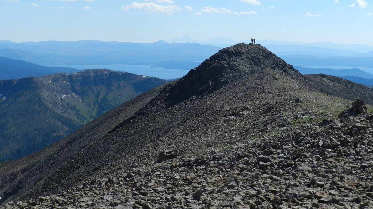 Two hikers enjoying the view from the summit of Avalanche Peak.