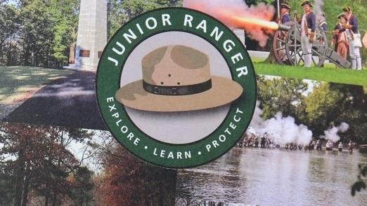 The cover of a junior ranger booklet with the wooden badge held in the lower left corner.