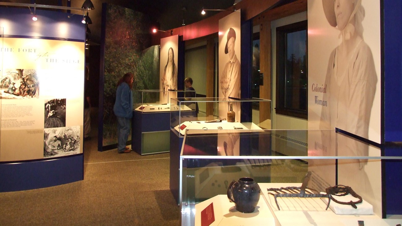 You can see three glass cases with artifacts inside and portraits next to them. 