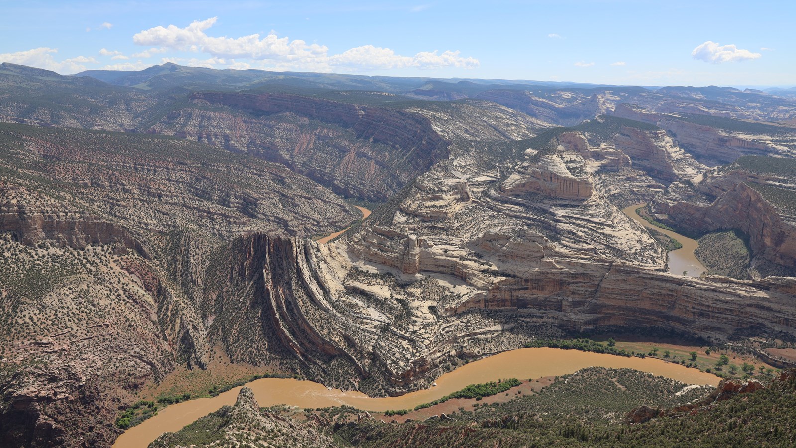 An expansive view of two rivers meeting and winding through large canyons.