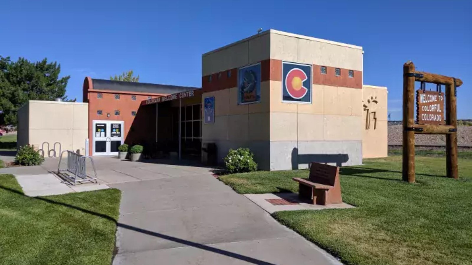 A large brown building with a wooden sign in the front.