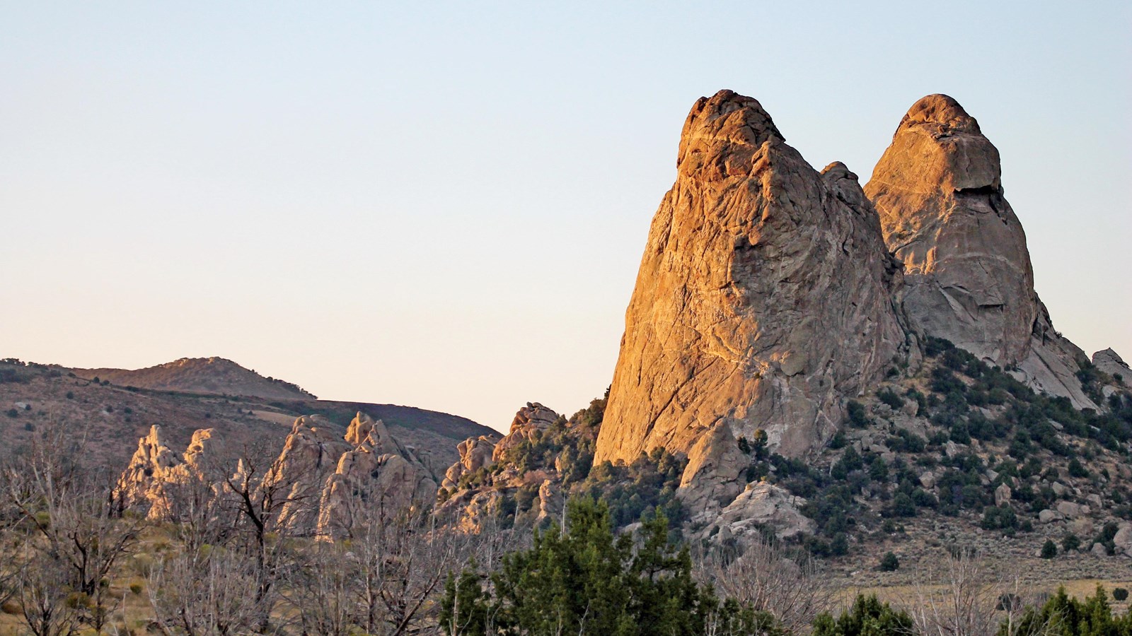 Towering twin granite spires highlighted by a golden sunset.