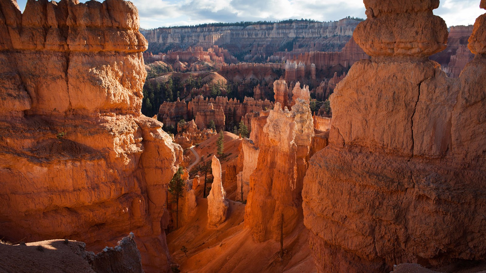A glowing landscape of red and orange rock spires and forest
