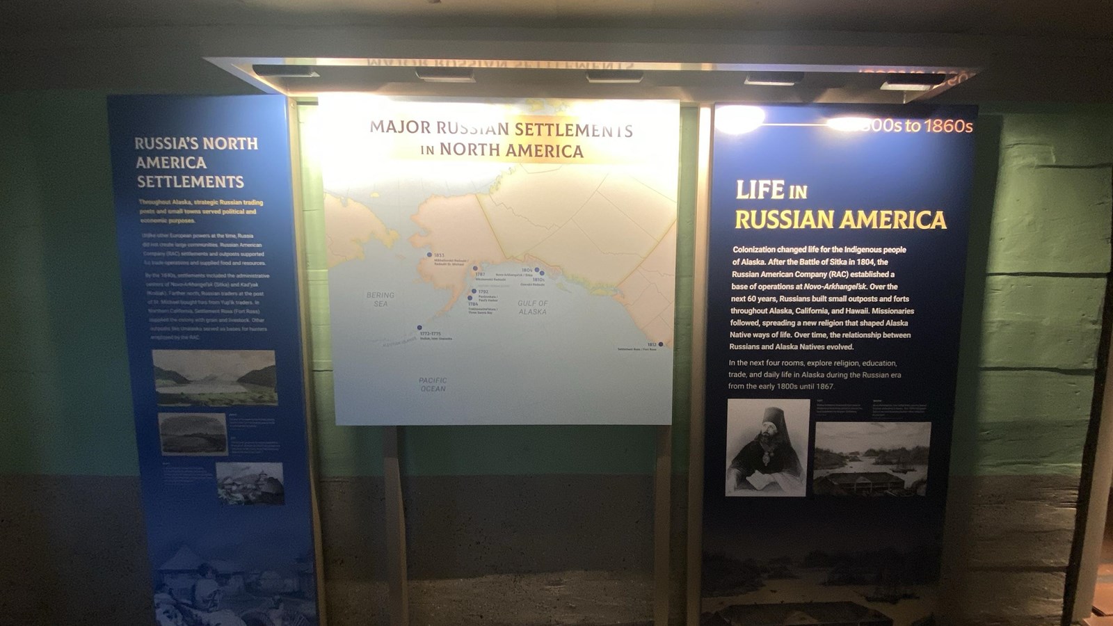 Squared beam walls painted light green blue and grey on bottom floors painted red exhibit map panel