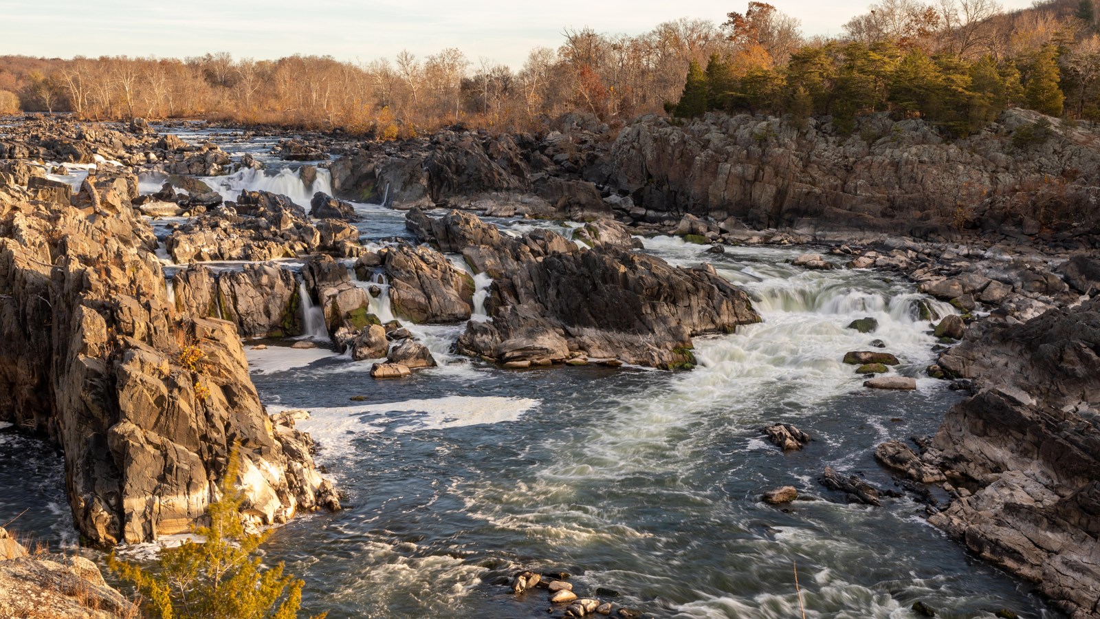 A rushing waterfall surrounded by large rock boulders