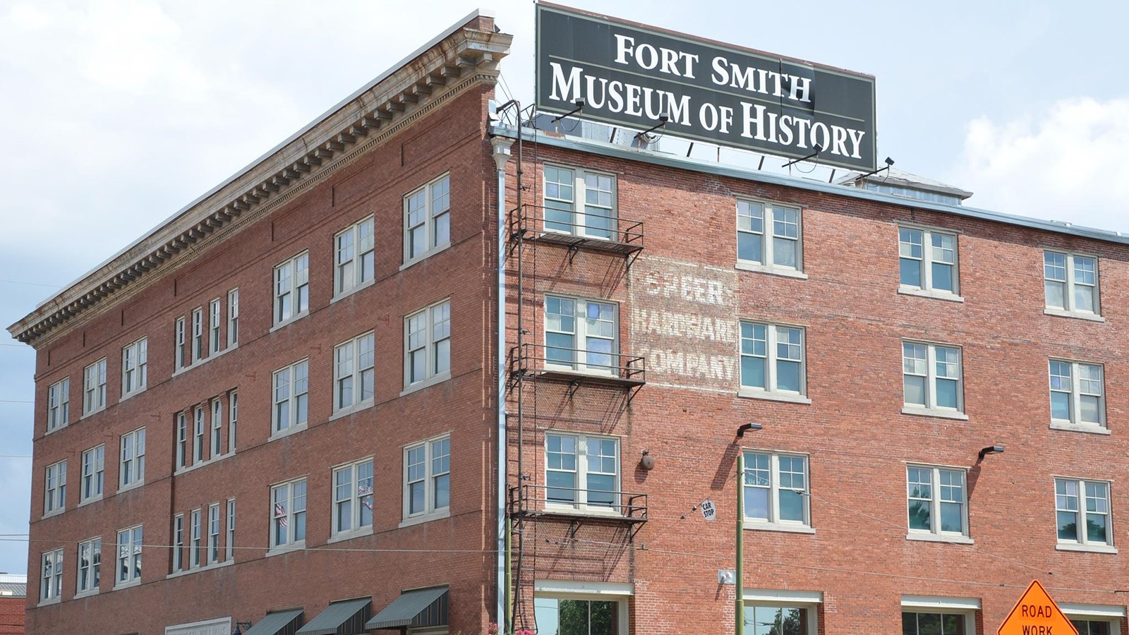 Four story red brick building with a large sign on the rood that reads Fort Smith Museum of History.