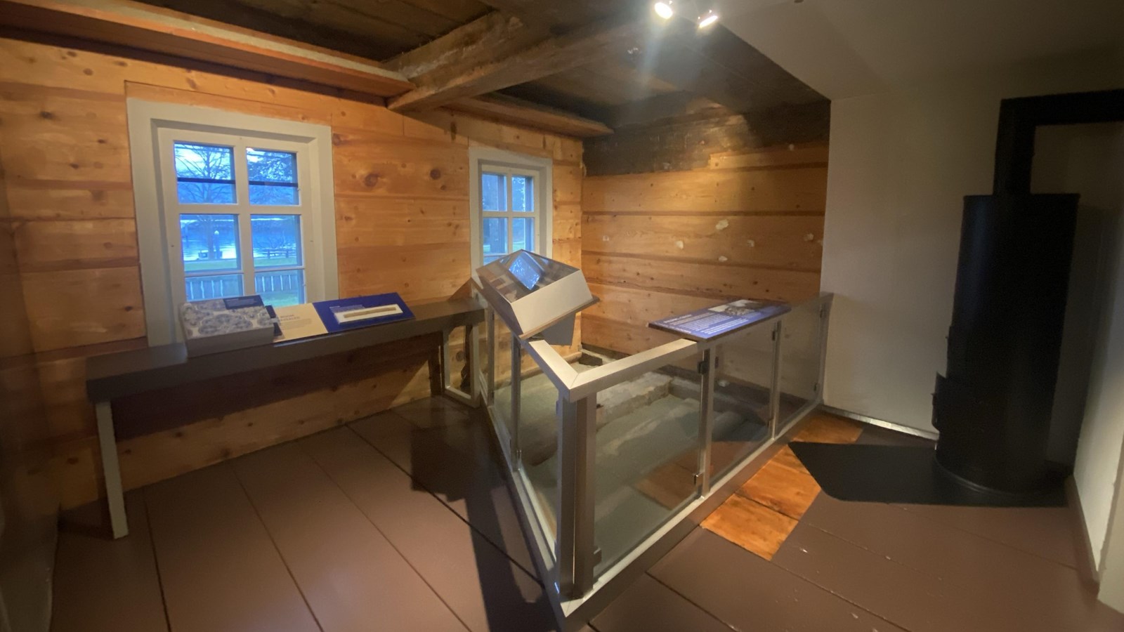 large black stove to the right of the doorway, part of the floor is gone with a railing around it 