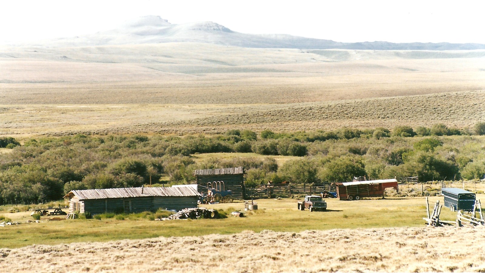 A small ranch in a high desert setting with distant hills.