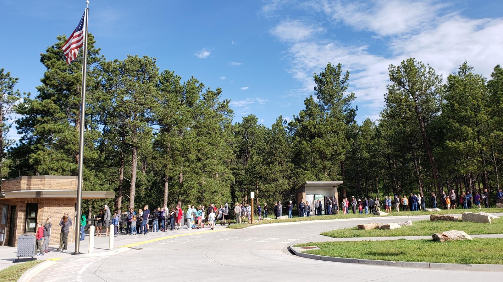 People wait in line at a small brick building