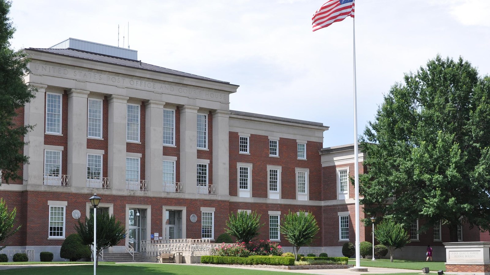 Three-story red brick, Classical Revival style, with limestone trim with two - two stories wings.