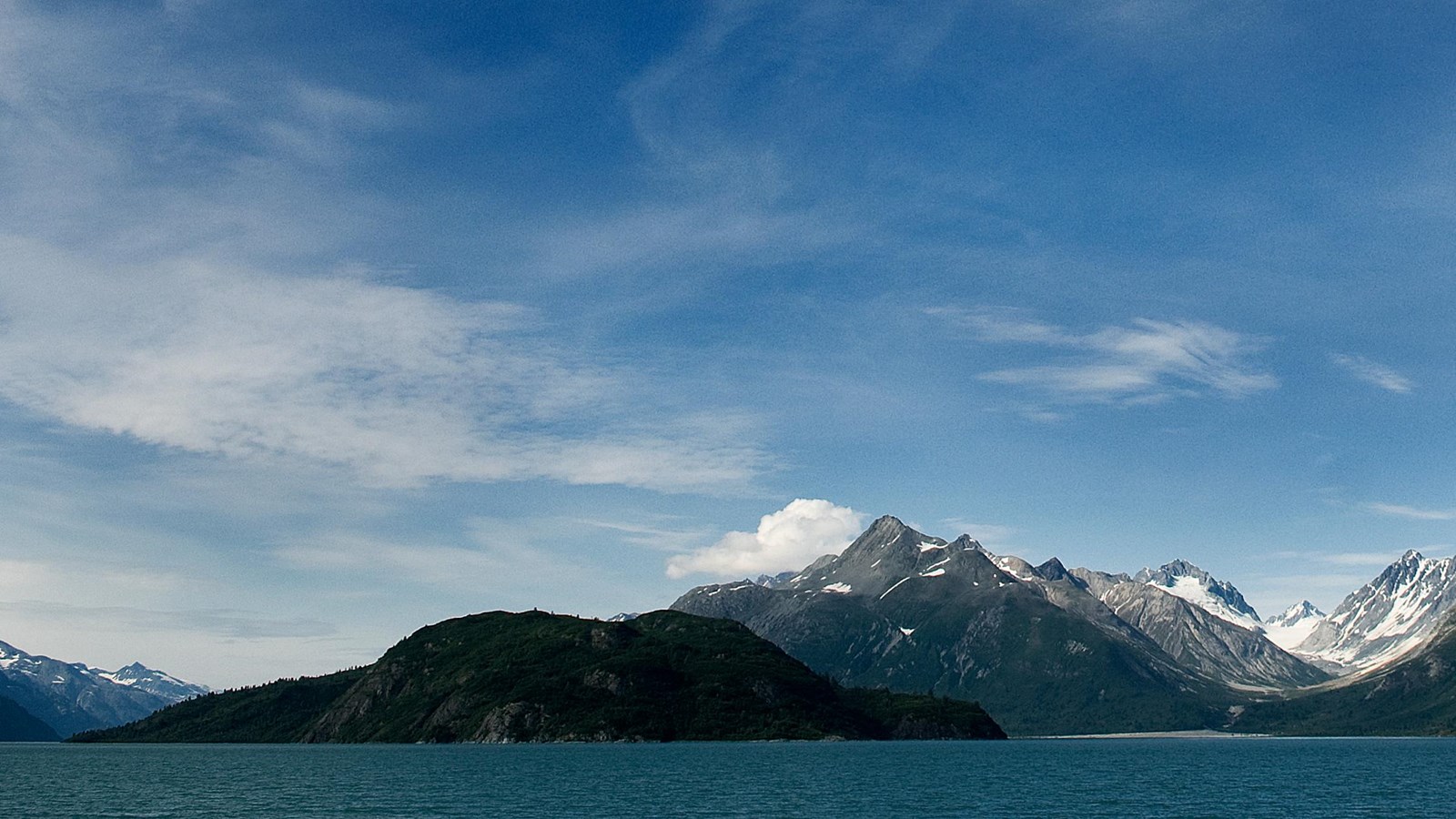 A shadowy Russell Island is viewed before a large, U-shaped valley in the mountains beyond.
