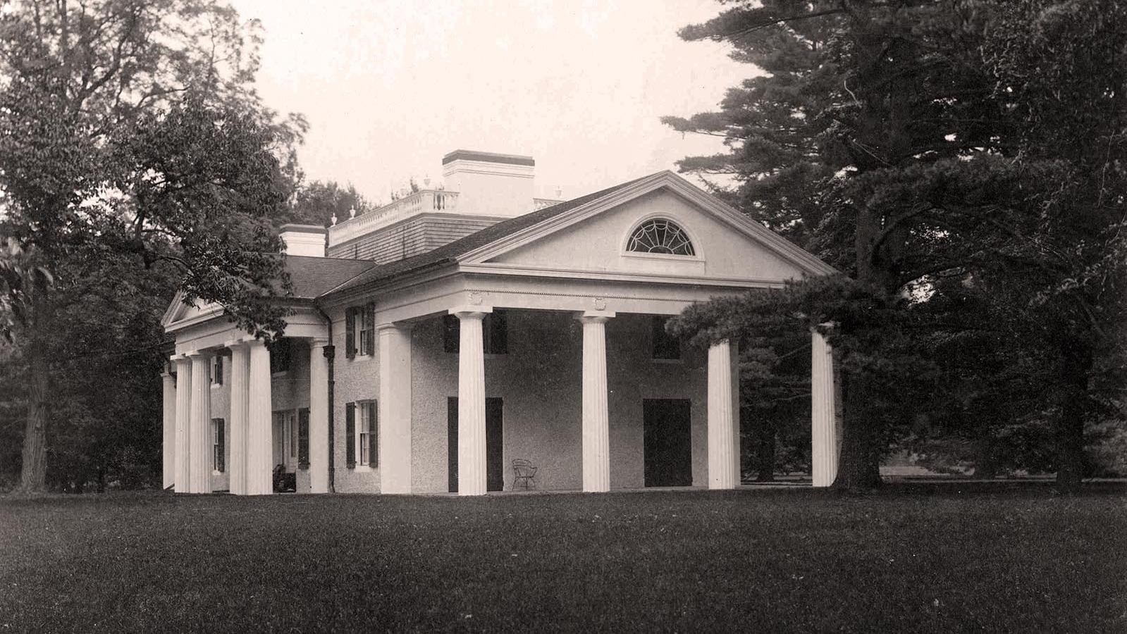 A classical building with pedimented portico and captain\'s walk on the roof.