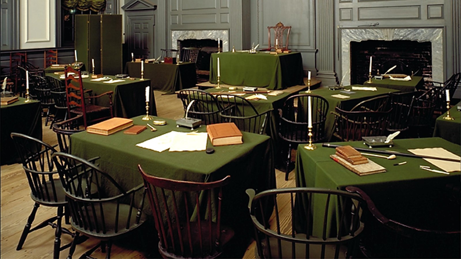 Interior view of a room with desks arranged in a semi-circle facing a central dias.