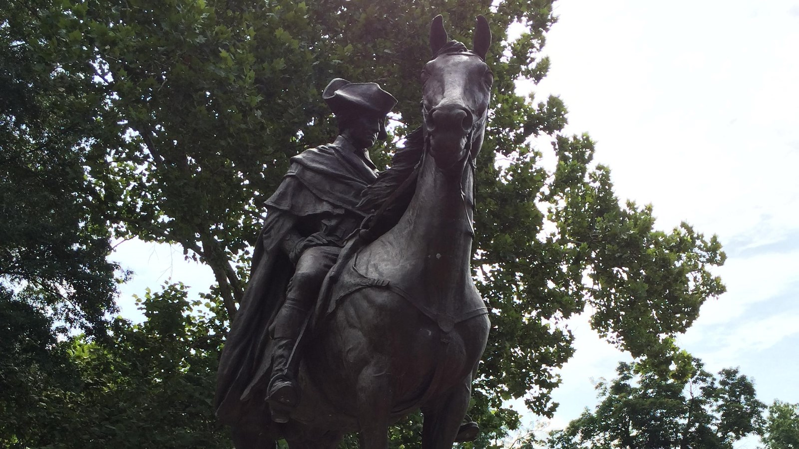 A bronze statue of George Washington mounted on horseback, on a pedestal.