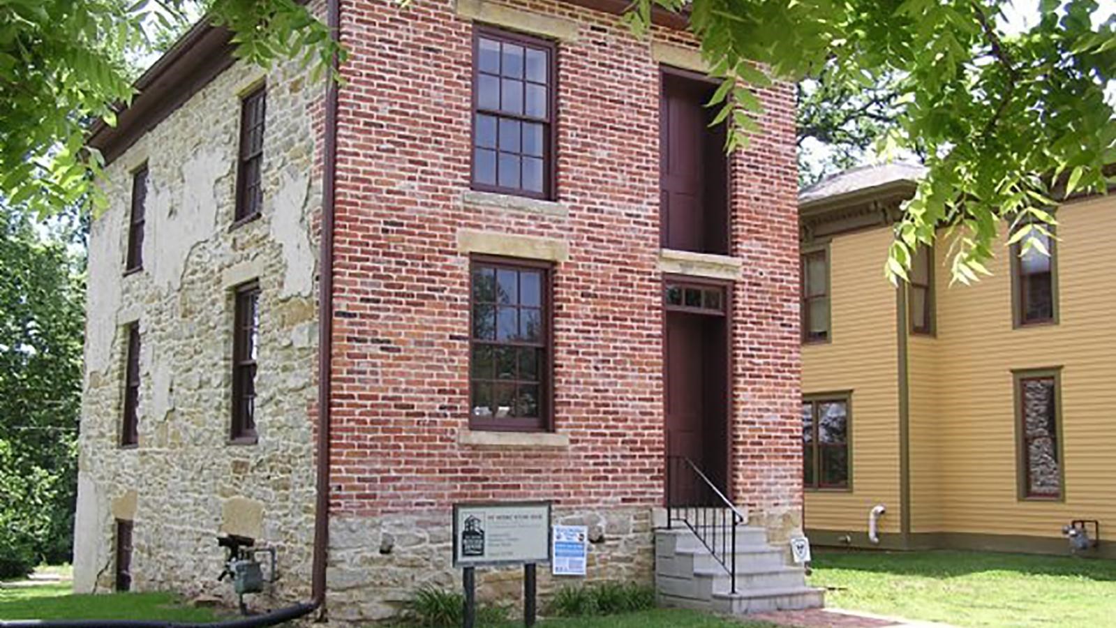 Brick two story building on grassy lawn.