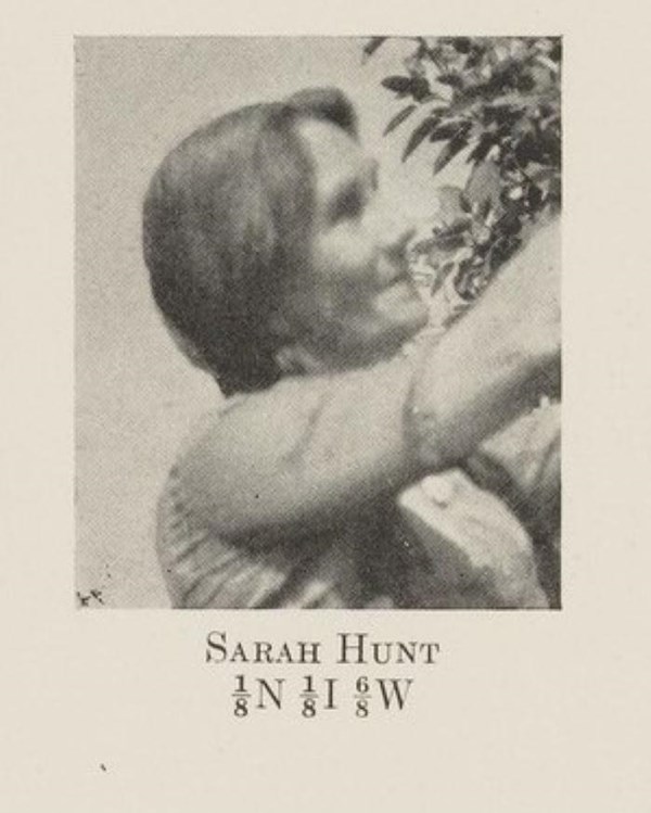 grainy photograph of woman in profile reaching up
