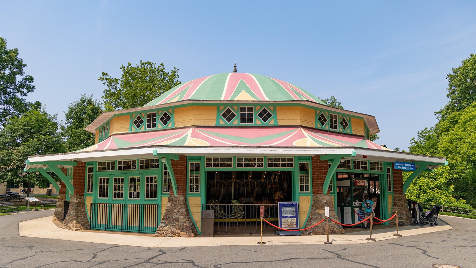 A lavishly decorated octagonal carousel structure houses a carousel with horses and other animals.