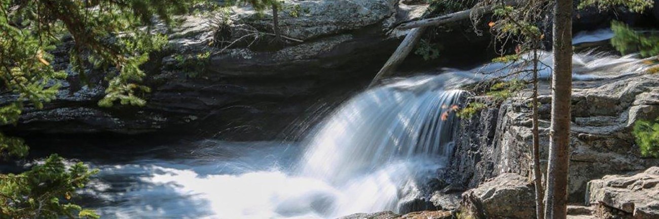 a waterfall flows over a rocky cliff
