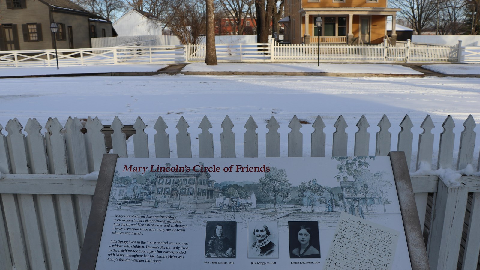 Outdoor Wayside Exhibit next to white fence, facing street.
